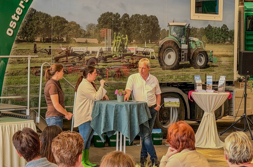 Vor dem Show-Truck sind Stehtische aufgebaut. An einem von diesen beantworten Andreas Osters und Stefanie Peters Fragen aus dem Kreis der Länderinnen